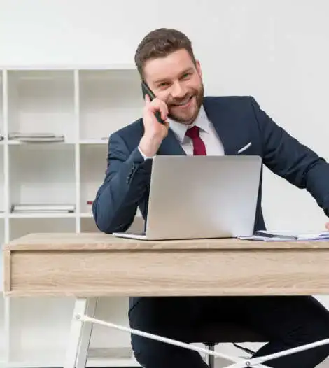 hombre con un portátil habla por teléfono